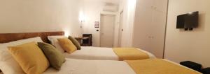 um quarto com 2 camas e uma televisão de ecrã plano em Affittacamere Armanino em Gênova