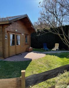 a yard with two chairs and a house at TinyHouse Meereszauber- ruhige Lage, eigener Garten, Grill in Wolgast +15 photos