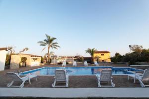 a pool with chaise lounge chairs and a resort at Villa Rita in Racale