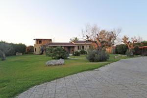 a house with a stone driveway in front of a yard at Villa Rita in Racale