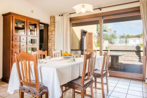 a dining room with a table and chairs and a large window at Villa Rita in Racale