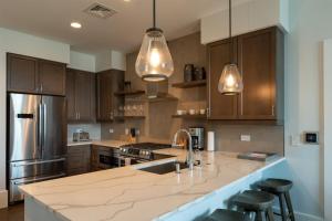 a kitchen with wooden cabinets and a counter top at 'The Views Over Pack Square Park' A Luxury Downtown Condo with Mountain and City Views at Arras Vacation Rentals in Asheville