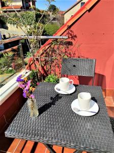 zwei Tassen und Untertassen auf einem Tisch auf einem Balkon in der Unterkunft Apartamento Carril - Camiño do Carro in Vilagarcia de Arousa