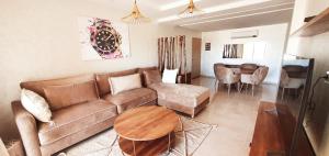 a living room with a couch and a table at COSY APPART avec 2 piscines, 2 CH, 2 SDB Marrakech in Marrakech
