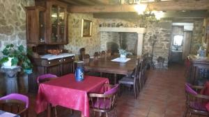 a dining room with a table and chairs and a fireplace at Casa pedrolo in Outes