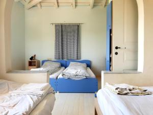 Pokój z 2 łóżkami i niebieską kanapą w obiekcie Cottage with Private Pool w Poros