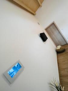 Zimmer mit einem TV an einer weißen Wand in der Unterkunft Abuelo Apartment in Artemida