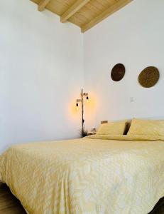 a bedroom with a large bed with white walls at Abuelo Apartment in Artemida