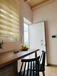eine Küche mit einem Tisch mit 2 Stühlen und einem Fenster in der Unterkunft Abuelo Apartment in Artemida