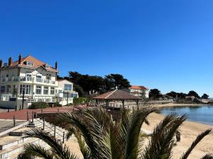 ein Gebäude am Strand neben einem Wasserkörper in der Unterkunft Hôtel de charme & SPA Le Grand Large in La Bernerie-en-Retz