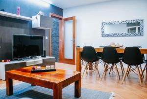 sala de estar con TV, mesa y sillas en Bird’s Home, en Aveiro