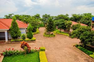 a garden with flowers and trees and a house at Mutheto Lodge in Lilongwe