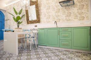 une cuisine avec des placards verts et une table dans l'établissement Golddem Blue, à Torremolinos