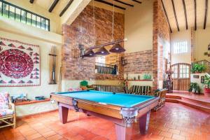 a pool table in a room with a brick wall at ANAPOIMA Villa Capri in Anapoima