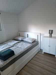 a bedroom with a bed and a white wall at Rykowisko - domki całoroczne nad jeziorem i rzeką in Szczecinek