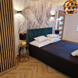 a bedroom with a bed with a green head board at Apartment Fay in Mali Lošinj