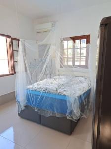 a bedroom with a bed covered in mosquito nets at Charmosa suíte de Tucuns. in Búzios +9 photos