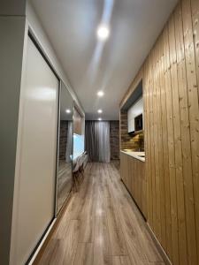 a kitchen with wood paneled walls and a hallway at Cozy Apartment in Orbi Bakuriani in Bakuriani