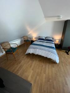 1 dormitorio con 1 cama grande y 2 sillas en Maison de pêcheur à 2 min de la Baie en Le Crotoy