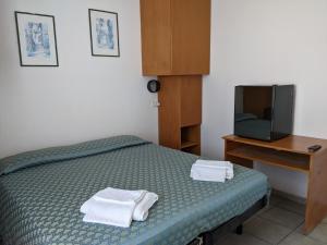 a bedroom with a bed and a small tv at Albergo casa del turista in Torre dell'Orso