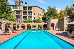 a large swimming pool with chairs and a building at Ski In, Ski Out, 2 Bedroom Luxury Residence With Hot Tub Access And Expansive Views in Snowmass Village