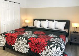 a bedroom with a bed with a red and white blanket at Lazy Cuckoo Inn - Sleek and Stylish Studio Apartments in Fort Myers Beach