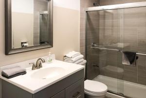 e bagno con lavandino, servizi igienici e doccia. di Lazy Cuckoo Inn - Sleek and Stylish Studio Apartments a Fort Myers Beach