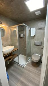 a bathroom with a shower and a toilet and a sink at Aux chambres du Banneret in Neuchâtel