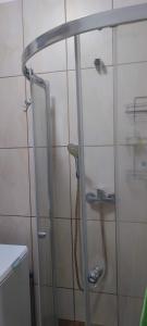 una ducha con una puerta de cristal junto a un lavabo en Warszawska, en Gdynia