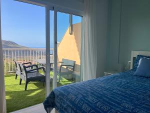 - une chambre avec un lit et un balcon avec une table et des chaises dans l'établissement Atico Mirador del Atlantico - Chayofa Vistas al Mar, à Chayofa