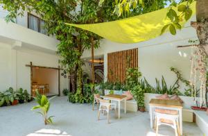 a patio with a table and chairs and plants at Niru Isle Maldives in Gaafaru