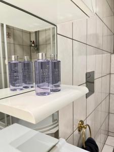 Baño con 3 botellas en estanterías en un espejo en Apartment Vienna - Contactless Check-In, en Viena