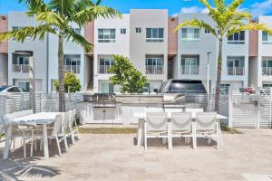 un patio con tavoli e sedie di fronte a un edificio di Lofts of Aventura a Miami