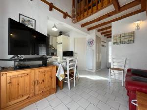 salon z telewizorem z płaskim ekranem na drewnianej szafce w obiekcie Charmante maison 3 pièces, 2 pas plage et forêt, 4 couchages, WIFI, stationnement, ménage inclus - St Georges d'Oléron - FR-1-246A-152 w mieście Saint-Georges-dʼOléron
