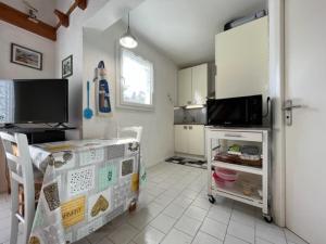 kuchnia ze stołem i kuchenką mikrofalową w obiekcie Charmante maison 3 pièces, 2 pas plage et forêt, 4 couchages, WIFI, stationnement, ménage inclus - St Georges d'Oléron - FR-1-246A-152 w mieście Saint-Georges-dʼOléron +4 zdjęcia
