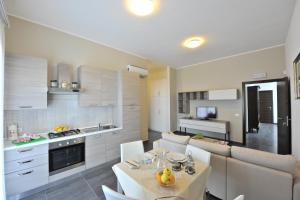 a kitchen and living room with a table and chairs at Case Mistretta in Altavilla Milicia