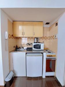 una pequeña cocina con fregadero y microondas en lindo departamento a 2 cuadras del obelisco en Buenos Aires