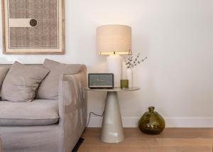a living room with a couch and a table with a lamp at Villa Sofia Cascais in Cascais