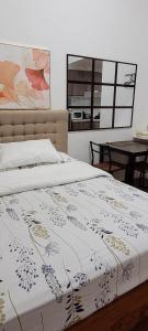 a bed with a white bedspread with flowers on it at White Oak Residences - Baguio Megatower 3 in Baguio