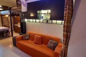 an orange couch sitting in a living room at Residenza nel borgo romano in Mentana