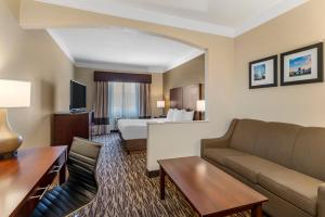 a hotel room with a couch and a bed at Comfort Suites Salem in Salem