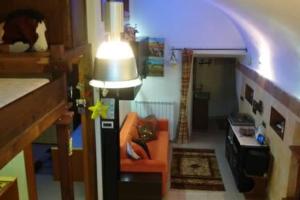 a living room with a lamp and an orange chair at Residenza nel borgo romano in Mentana