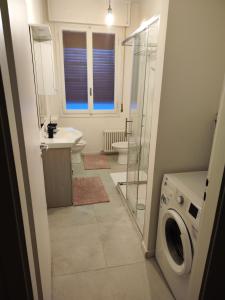 a bathroom with a sink and a washing machine at Ak Holidays Apartment 59 in Bologna