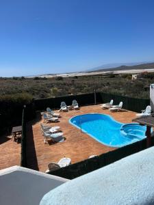 einen Pool mit Liegestühlen und Strand in der Unterkunft El Rincón de los Albaricoques in Níjar