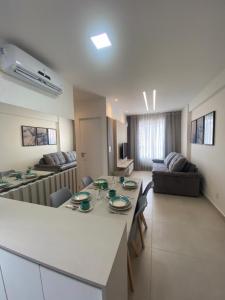uma cozinha e sala de estar com uma mesa e um sofá em Promenade II Ap 508 PONTA VERDE - MACEIÓ em Maceió