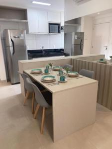 uma cozinha com uma mesa com pratos em Promenade II Ap 508 PONTA VERDE - MACEIÓ em Maceió