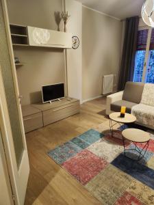 Una sala de estar con un sofá y un televisor. en Ak Holidays Apartment 59, en Bolonia
