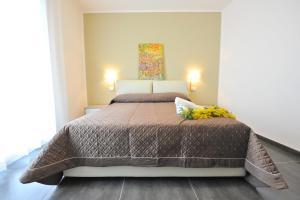 a bedroom with a bed with a brown comforter at Case Mistretta in Altavilla Milicia