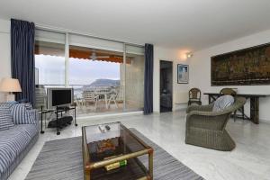 a living room with a couch and a tv at Grand bleu, appartamento vista mare e Monaco in Roquebrune-Cap-Martin