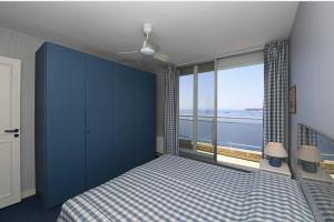 a bedroom with a bed and a large window at Grand bleu, appartamento vista mare e Monaco in Roquebrune-Cap-Martin